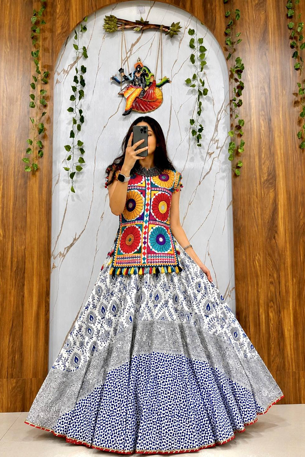 Person wearing a colorful traditional outfit with a wooden and decorative wall background