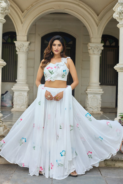Woman in a white embroidered outfit standing in an architectural setting