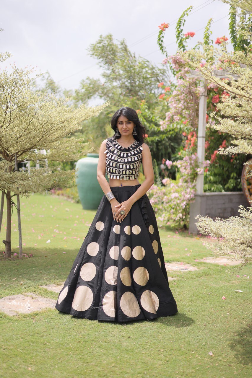 Woman in a black and white patterned outfit standing in a garden.