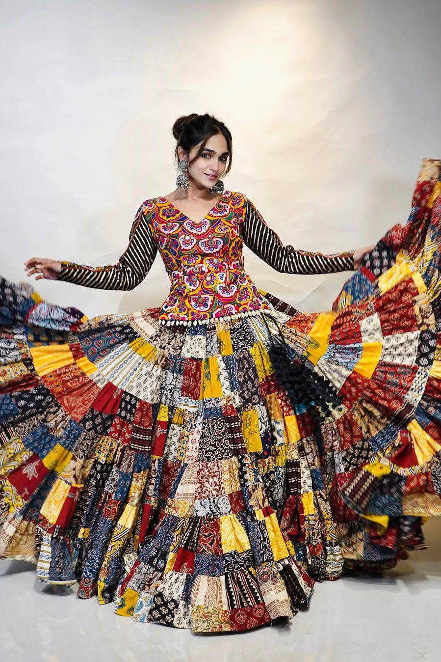 Woman wearing a colorful patchwork dress with a plain background